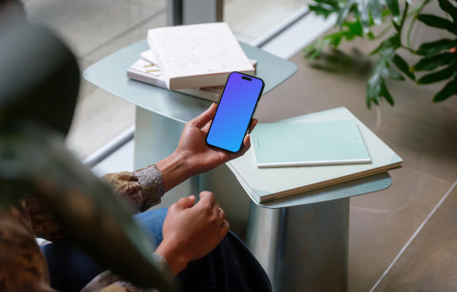 Hand holding an iPhone 14 Pro mockup