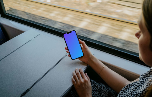 Woman hand holding an iPhone 13 mockup