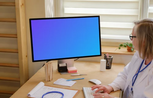 Female doctor typing on an Apple Studio Display