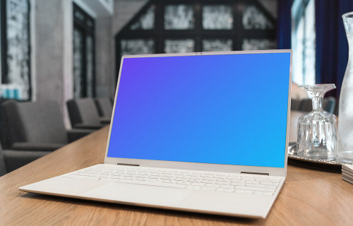 White Dell XPS Mockup on a table with wine glasses at the side