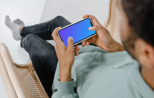 iPhone mockup held by user in landscape mode